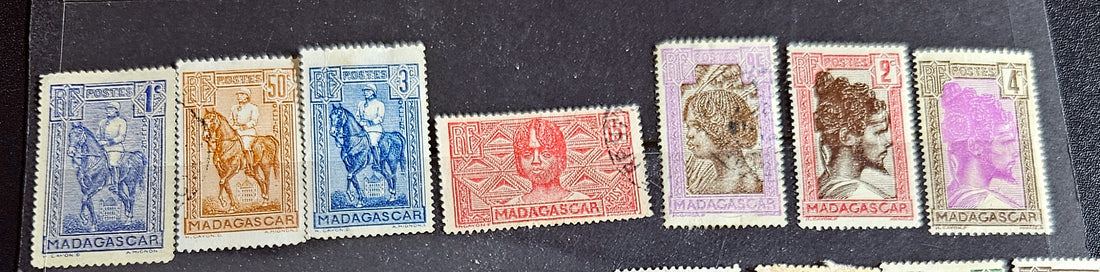 A set of vintage stamps from French Madagascar, featuring various designs including floral patterns and portraits.