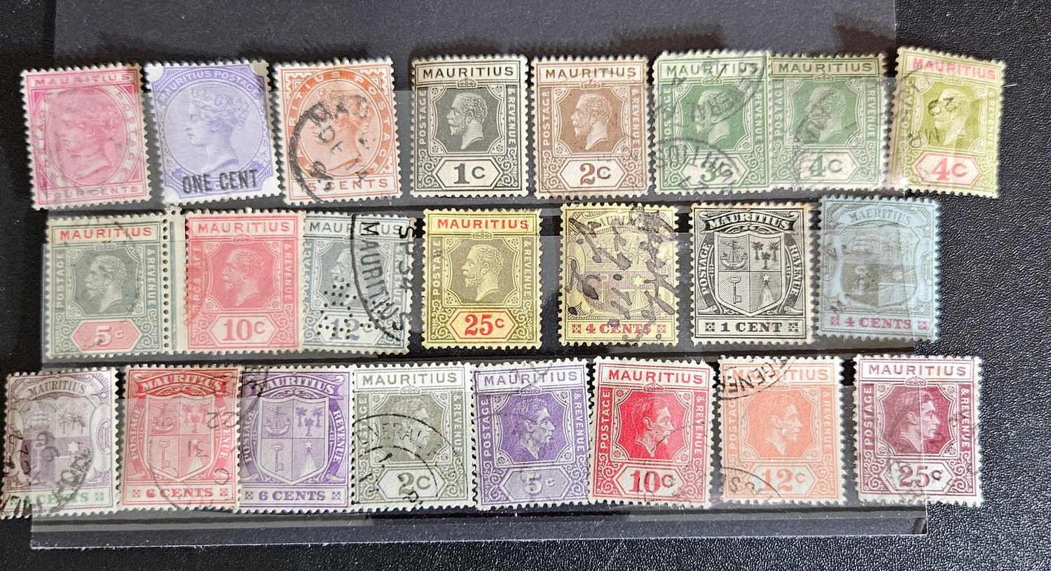 A collection of vintage postage stamps from Mauritius displayed in a row, featuring various designs and denominations.