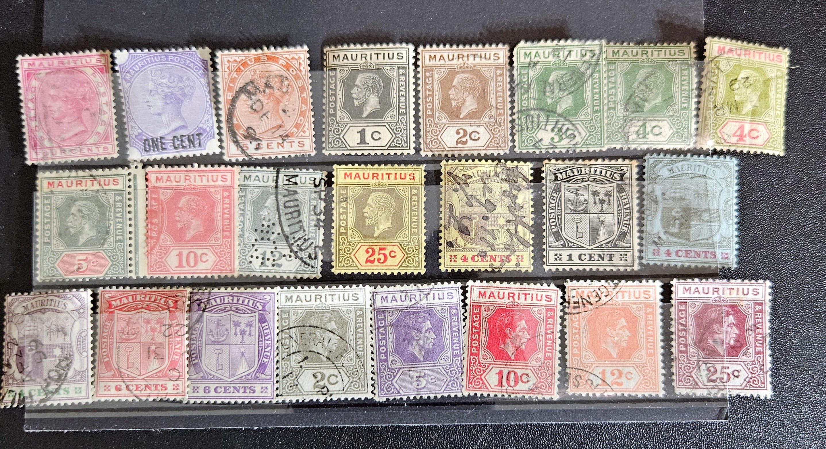 A collection of vintage postage stamps from Mauritius displayed in a row, featuring various designs and denominations.