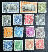 A collection of vintage British Nigeria stamps displayed on a surface, featuring various colors and motifs related to different eras in Nigerian history.