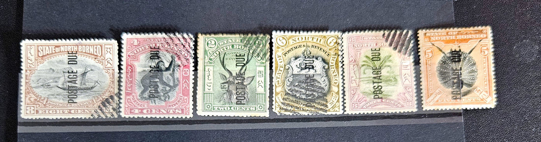 A set of vintage postage stamps from North Borneo and Sabah with various designs and denominations.