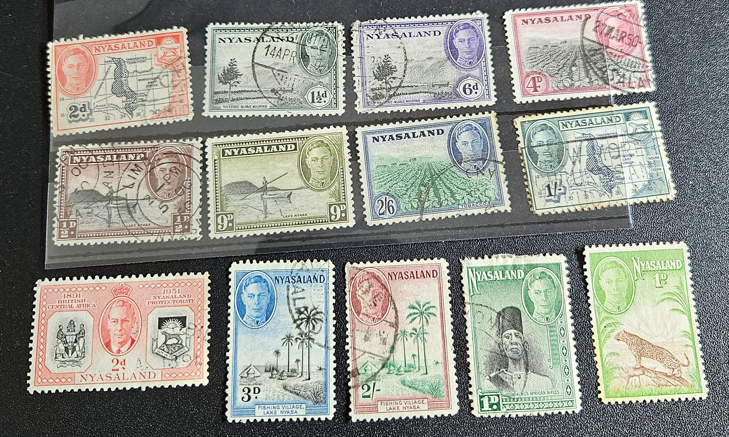 A collection of Nyasaland vintage stamps displaying various images and text, arranged in a row.