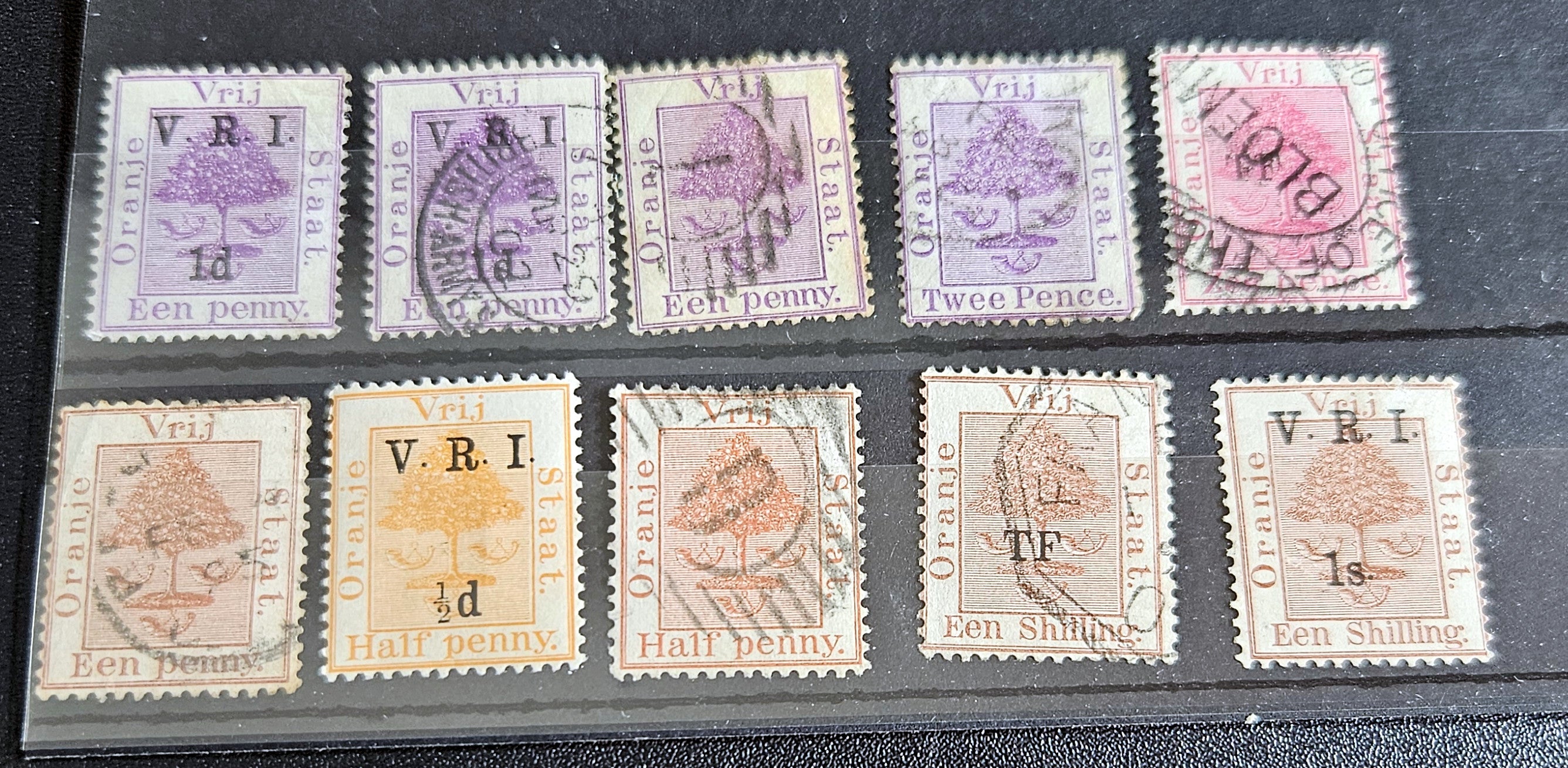 A collection of vintage postage stamps from the Orange Free State, featuring various denominations and cancellation marks, housed in a plastic sleeve.