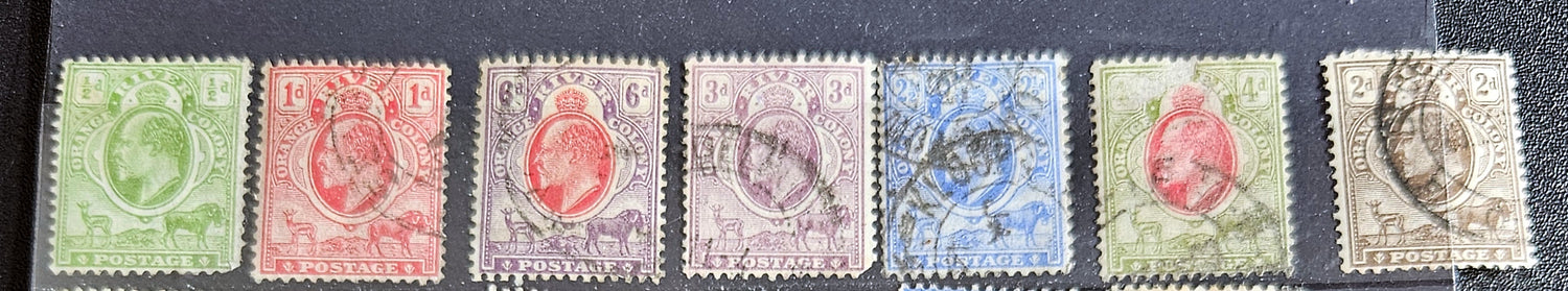 A collection of vintage postage stamps from the Orange Free State, featuring various denominations and cancellation marks, housed in a plastic sleeve.