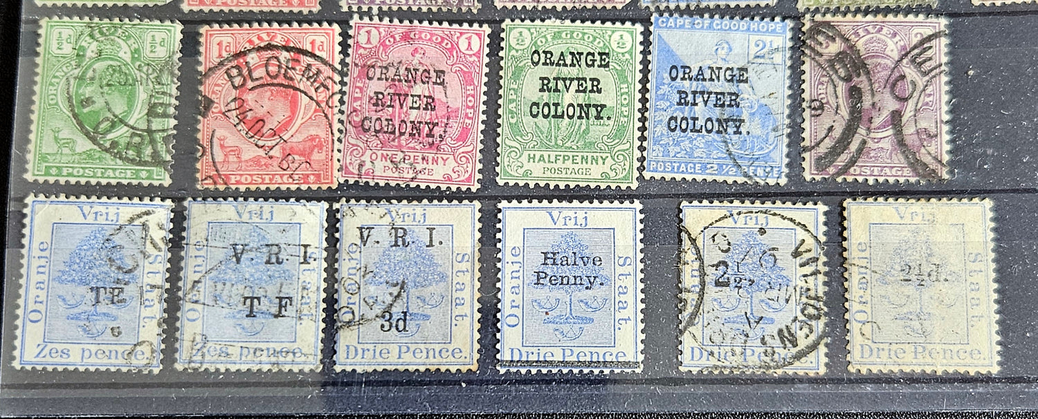 A collection of vintage postage stamps from the Orange Free State, featuring various denominations and cancellation marks, housed in a plastic sleeve.