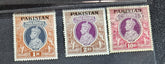 A collection of vintage Pakistan stamps from various periods, showing different designs and denominations, displayed on a glass surface.
