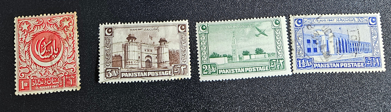 A collection of vintage Pakistan stamps from various periods, showing different designs and denominations, displayed on a glass surface.