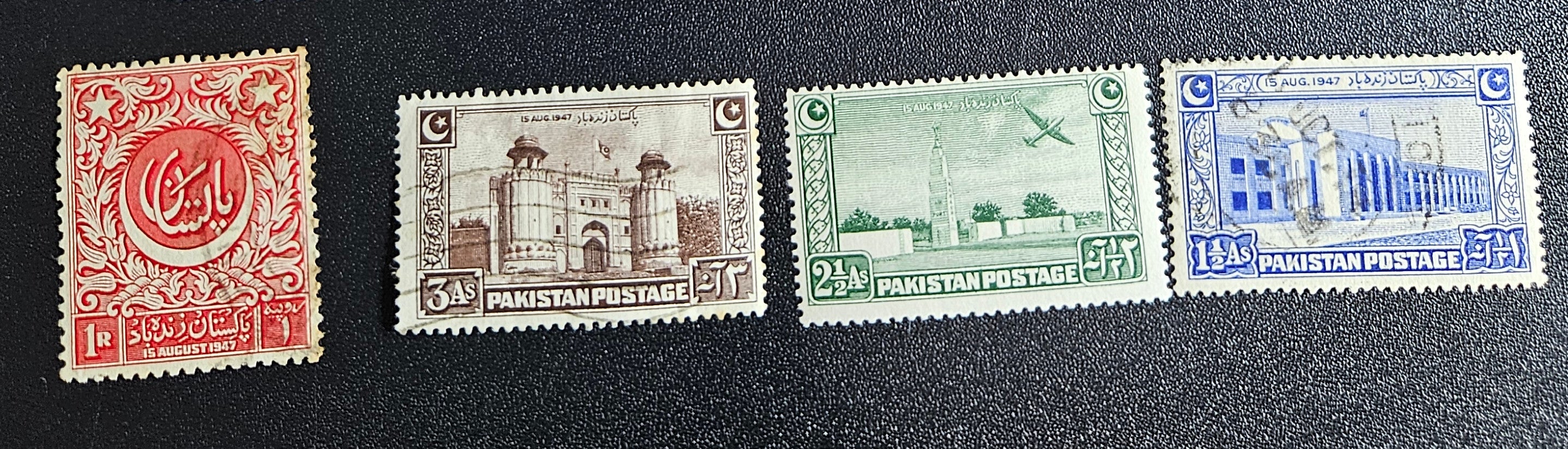 A collection of vintage Pakistan stamps from various periods, showing different designs and denominations, displayed on a glass surface.