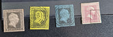 Four vintage Prussian postage stamps in different colors (gray, yellow, blue-gray, and pinkish-red) aligned horizontally on a black textured background.