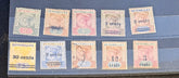 A set of ten vintage Seychelles postage stamps arranged in two rows on a dark display surface. The stamps show different denominations including 2, 4, 3 cents, 30 cents, 3, 12, and 3 cents, with various colors and postmarks.