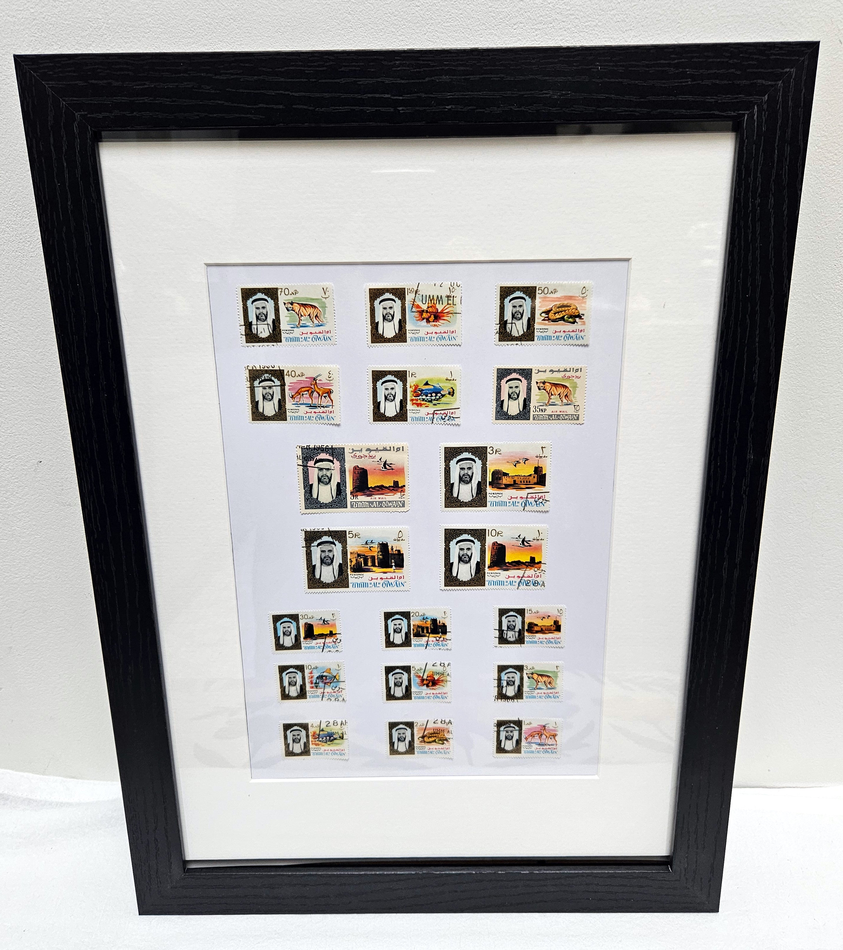 Framed collection of Umm Al Quwain stamps on a white background