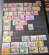 A collection of various vintage Malay state stamps displayed in a row, showcasing different colors and designs.