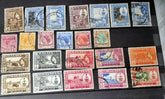A collection of various vintage Malay state stamps laid out on a surface.