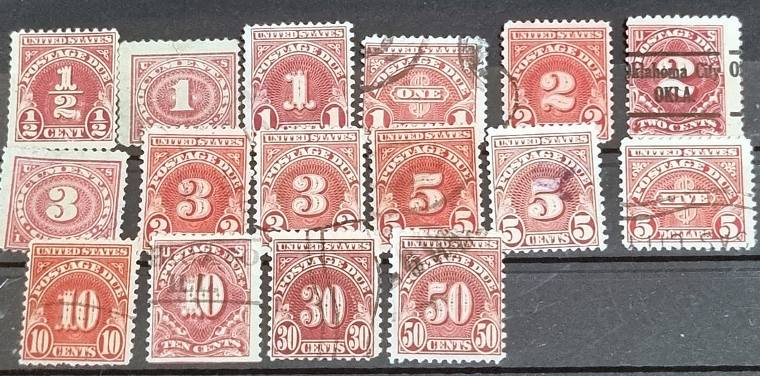 A collection of vintage red US postage due stamps with various denominations.