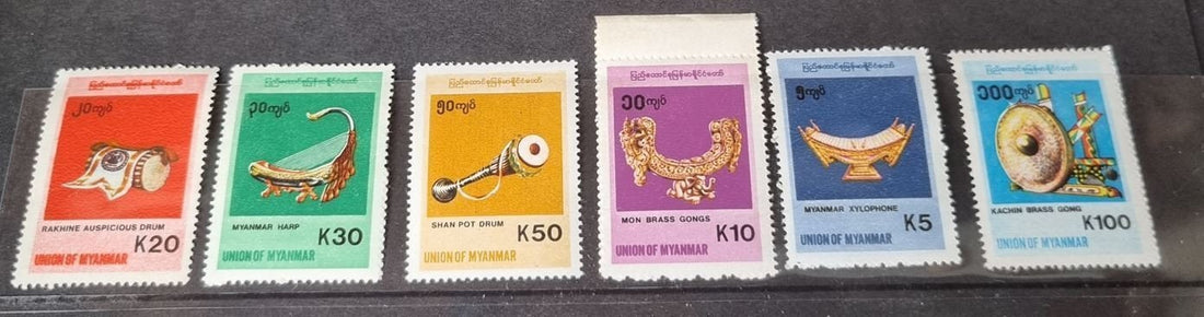 A set of six colorful postage stamps featuring various musical instruments, with a focus on traditional Burmese instruments.