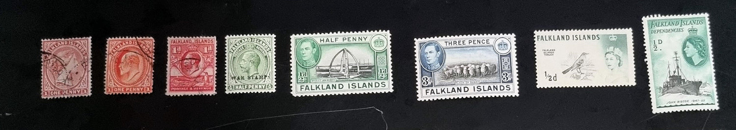 A set of vintage Falkland Islands stamps from various reigns, displayed in a row.