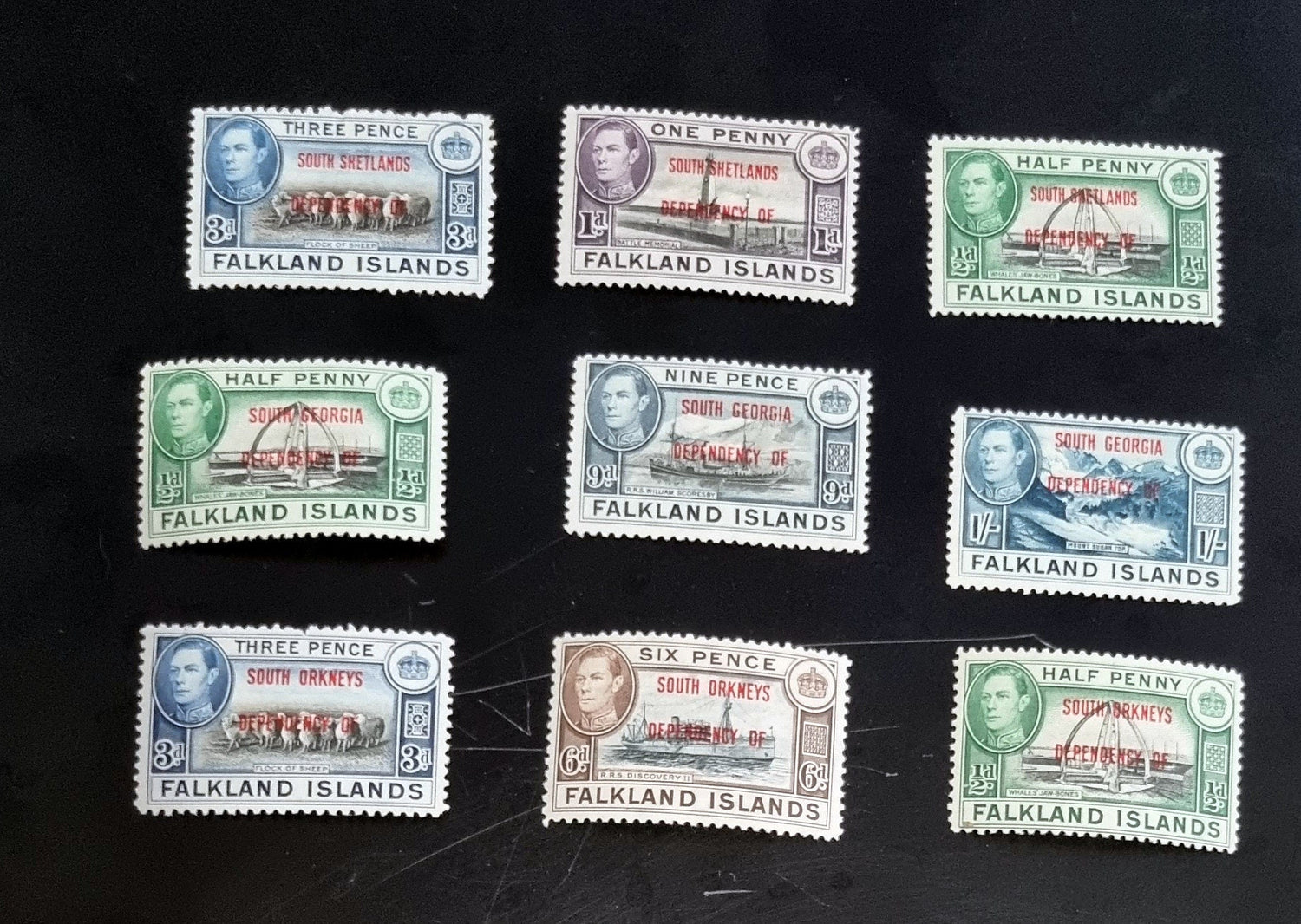 A set of vintage Falkland Islands stamps from various reigns, displayed in a row.