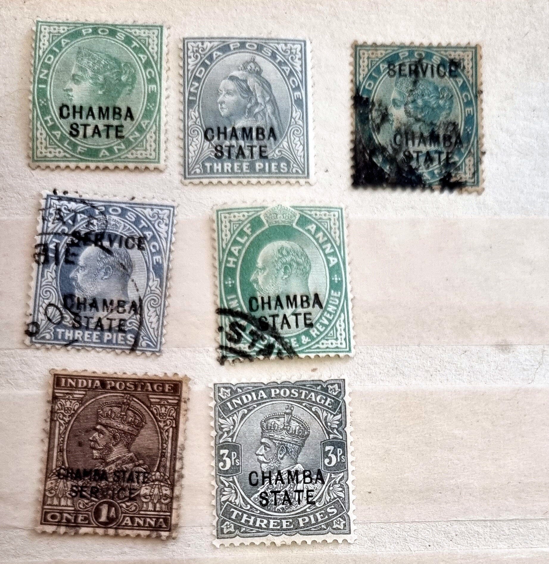 A collection of various Indian postage stamps displayed in a row, showcasing different colors and designs.
