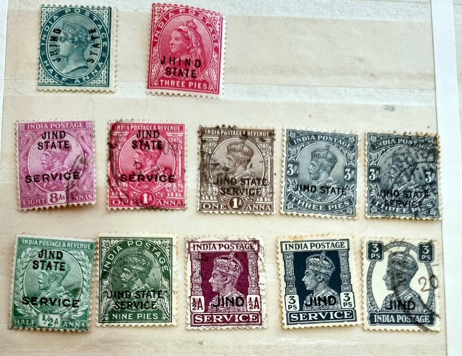 A collection of various Indian postage stamps displayed in a row, showcasing different colors and designs.