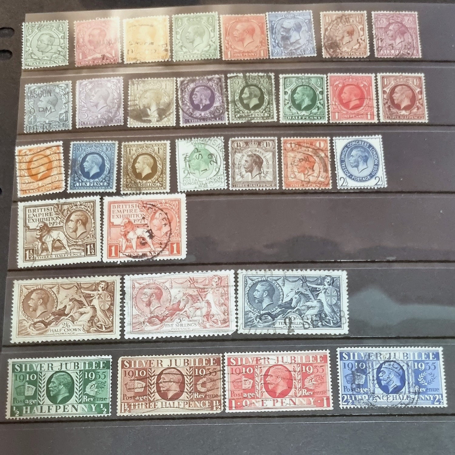 A collection of various vintage postage stamps featuring portraits of King George V, with a focus on stamps from the 1920s and 1930s.