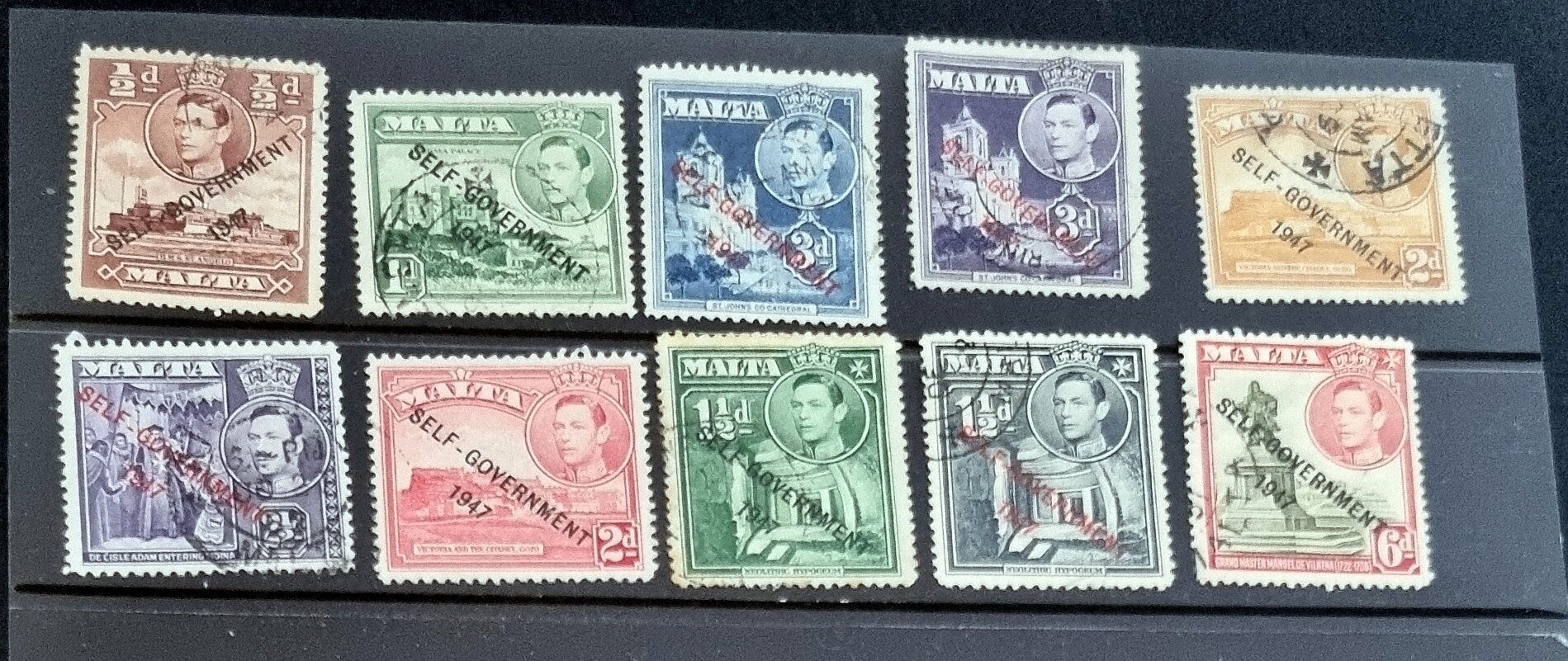 A collection of vintage postage stamps from Malta featuring various designs and colors, arranged in no specific order on a surface.