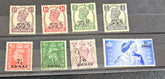 A collection of various denominations of British Post Office stamps from Muscat, Oman, laid out on a flat surface.
