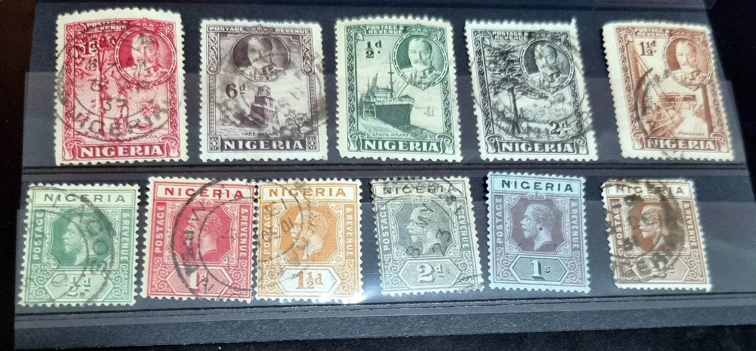 A collection of vintage British Nigeria stamps displayed on a surface, featuring various colors and motifs related to different eras in Nigerian history.