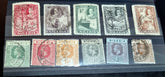 A collection of vintage British Nigeria stamps displayed on a surface, featuring various colors and motifs related to different eras in Nigerian history.