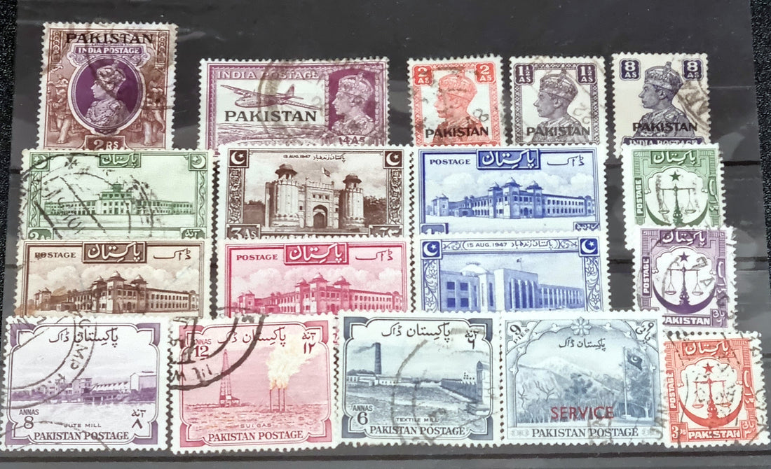 A collection of vintage Pakistan stamps from various periods, showing different designs and denominations, displayed on a glass surface.