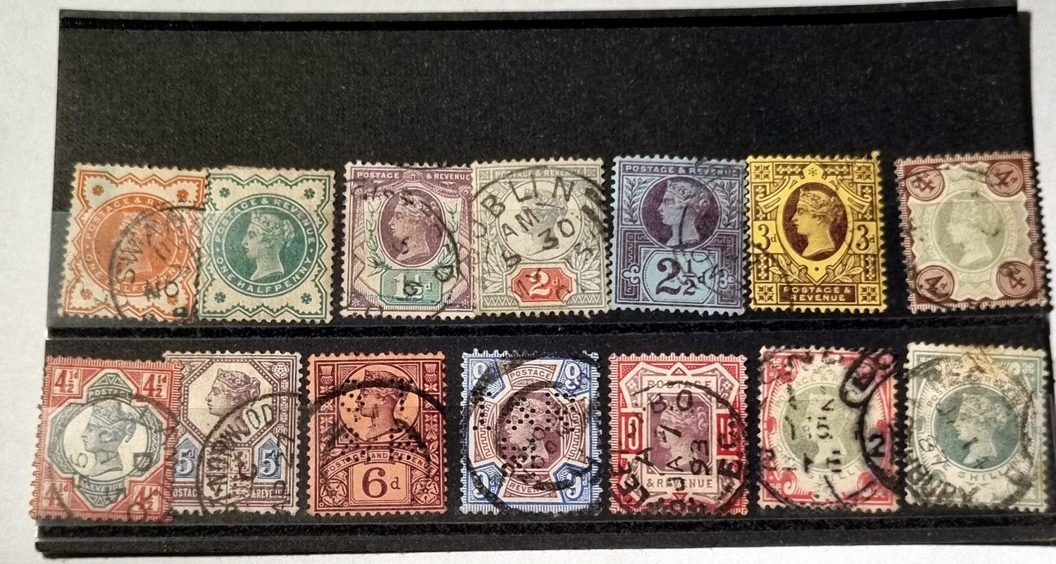 A collection of vintage Queen Victoria Jubilee stamps, displayed in a row, varying in color and design, set against a black background.